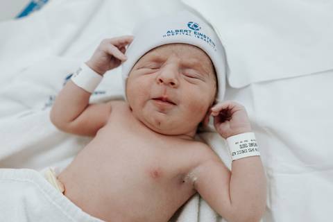 Foto de close do bebê recém-nascido com expressão serena.'