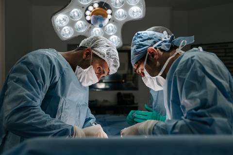 Foto dos cirurgiões concentrados durante o procedimento de nascimento.'