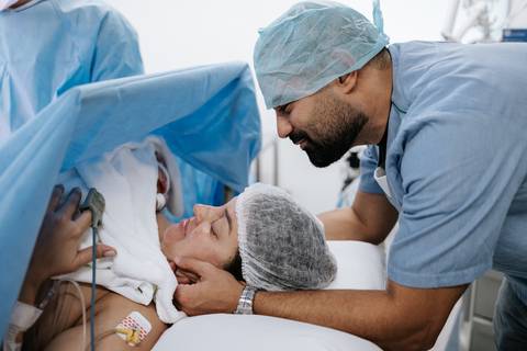 Foto do casal conhecendo o filho logo após o nascimento.'