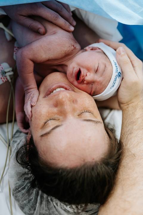 Close da mãe em primeiro contato pele a pele com o bebê. '
