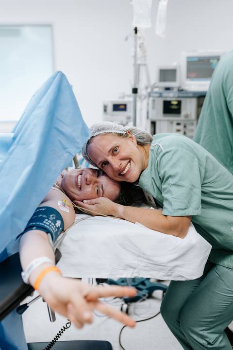 Foto da gestante sorrindo com equipe médica. '