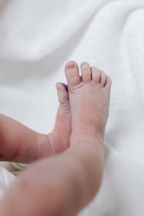 Detalhe dos pezinhos do bebê com a marca da tinta de identificação.'