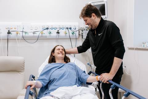 Casal trocando olhares e sorrisos na sala de preparação.'
