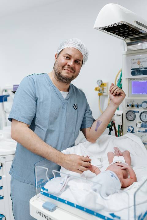 Pai mostrando o carimbo do pezinho no braço.'