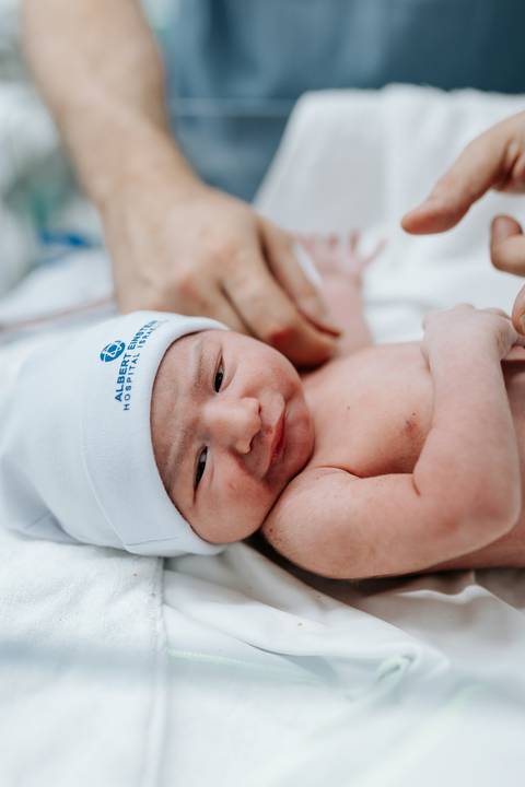 Close do bebê com a touca da maternidade Albert Einstein.'