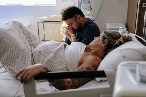 Foto da gestante em concentração com o parceiro ao lado.'