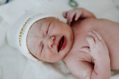 Foto de close da bebê chorando em seus primeiros minutos.'