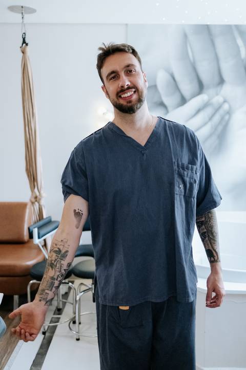 Foto do pai mostrando o carimbo do pezinho em seu braço.'