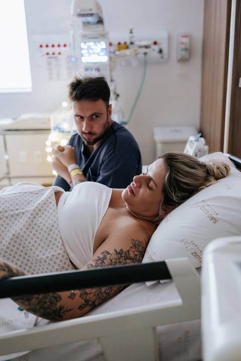 Foto do parceiro apoiando a gestante durante contração.'