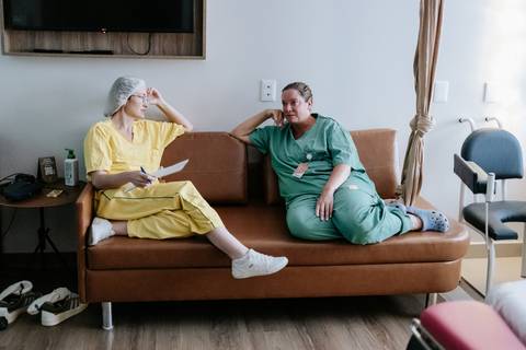 Foto da equipe monitorando o parto no sofá do quarto.'