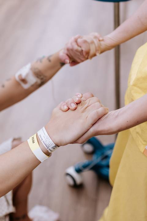 Foto em detalhe das mãos dadas em apoio durante os exercícios. '