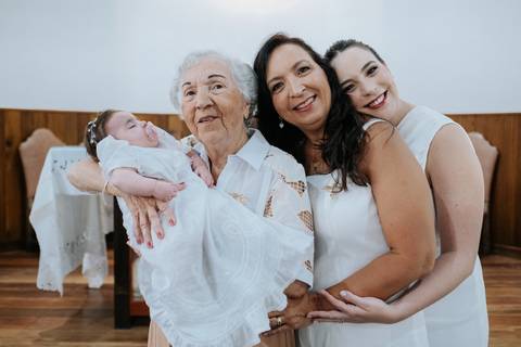 Foto da bisavó segurando Olívia acompanhada da mãe e avó.'