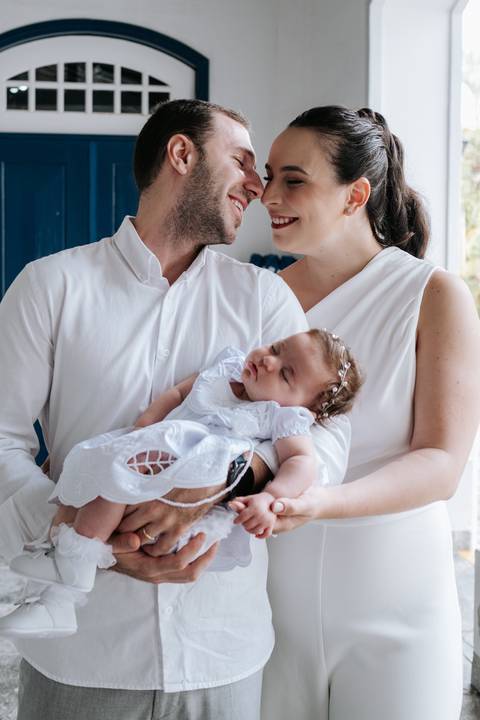 Foto aproximada dos pais com Olívia no colo.'