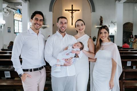 Foto do casal com padrinhos sorrindo no altar.'