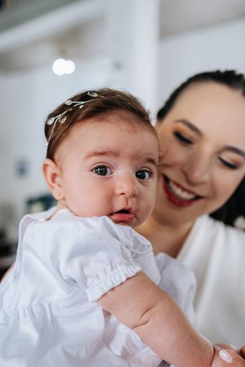 Foto da mãe sorrindo ao lado do rosto da filha.'