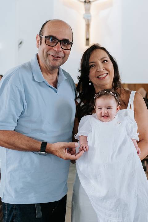 Foto da bebê Olívia com familiares após a cerimônia.'