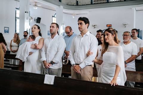 Foto dos pais e padrinhos com atenção na cerimônia. '