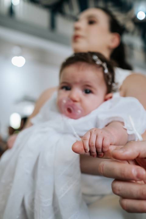 Foto de close da bebê Olívia com sua chupeta rosa.'
