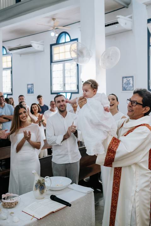 Foto da bebê sendo erguida e apresentada à comunidade.'