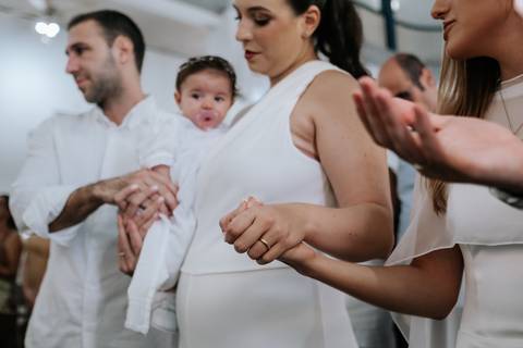 Foto dos pais e padrinhos de mãos dadas. '