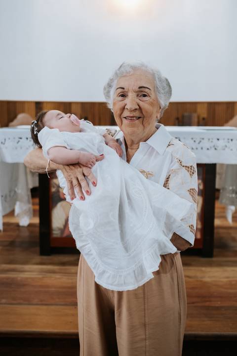 Foto da bisavó segurando a bisneta com o mandrião branco.'