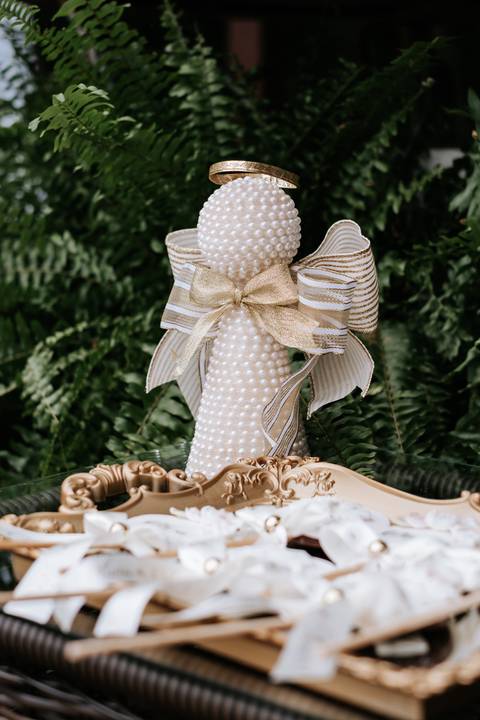 Foto em detalhe de um anjinho de pérolas decorativo.'