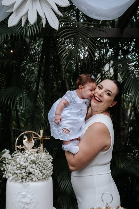 Foto da mãe recebendo um beijo no rosto da pequena Olívia.'