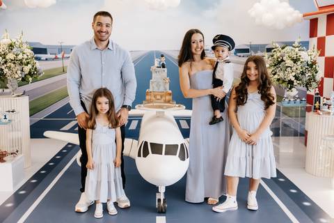 Foto oficial da família com todos sorrindo na mesa principal.'