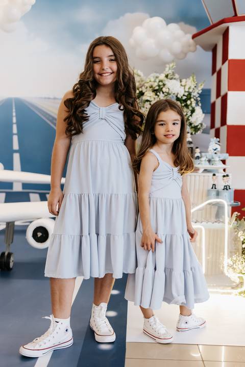 Foto das duas irmãs com vestidos azuis combinando.'