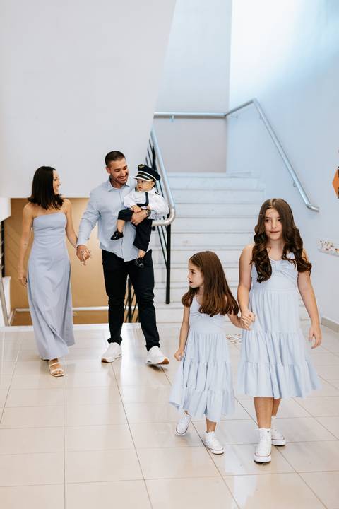 Foto da família completa posando na escada da festa.'