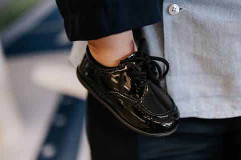 Foto em detalhe do sapato social preto do aniversariante.'