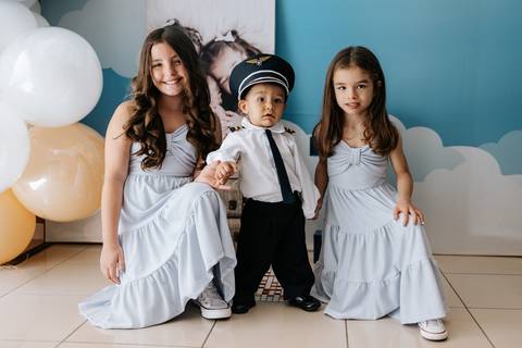 Foto do aniversariante posando com as duas irmãs.'