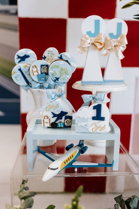 Foto aproximada de itens de decoração temáticos sobre uma mesa azul.'