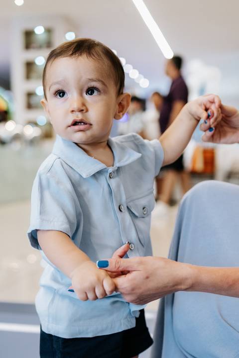 Foto de close das mãos do aniversariante em trajes de piloto.'