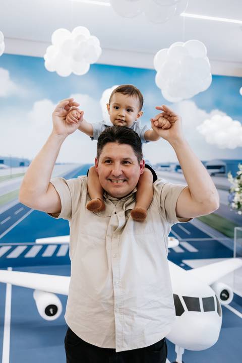 Foto do convidado segurando o aniversariante nos ombros no centro da pista.'