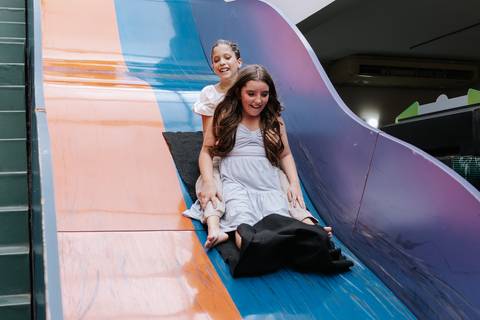 Foto das irmãs escorregando juntas no toboágua da festa.'