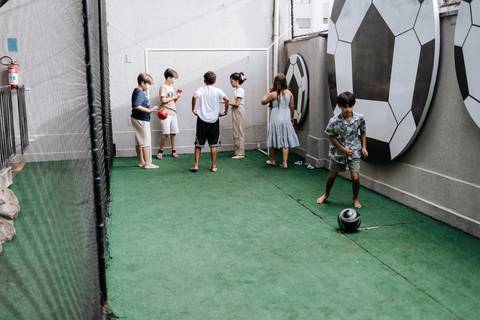 Foto de crianças jogando futebol na quadra do buffet.'
