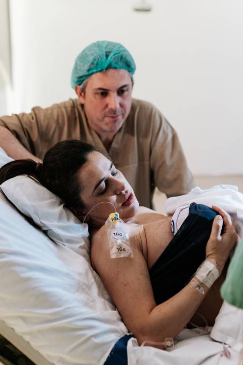 Foto da mãe e pai em momento de  união pós-parto.'