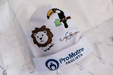 Foto em detalhe de touca da Pro Matre com desenhos de bichinhos.'
