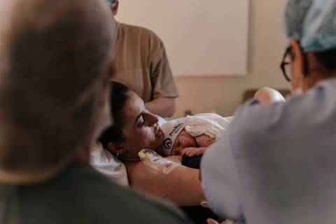 Foto da mãe com o Guilherme no colo logo após o nascimento.'