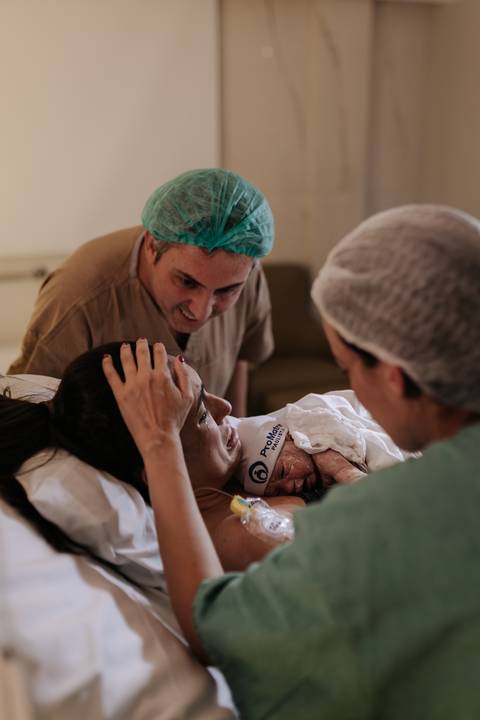 Foto da mãe emocionada ao ver o bebê pela primeira vez.'
