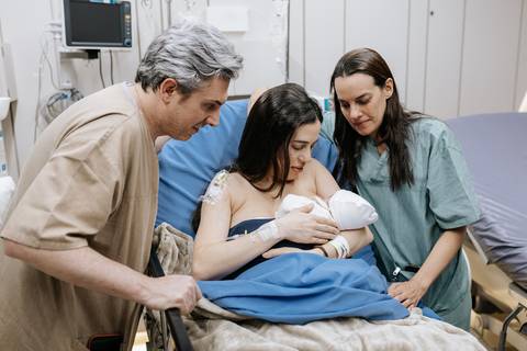 Foto da família completa e irmã reunidos na sala de recuperação.'