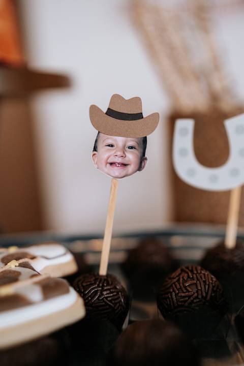 Foto de topper divertido com o rosto do aniversariante usando chapéu de cowboy.'