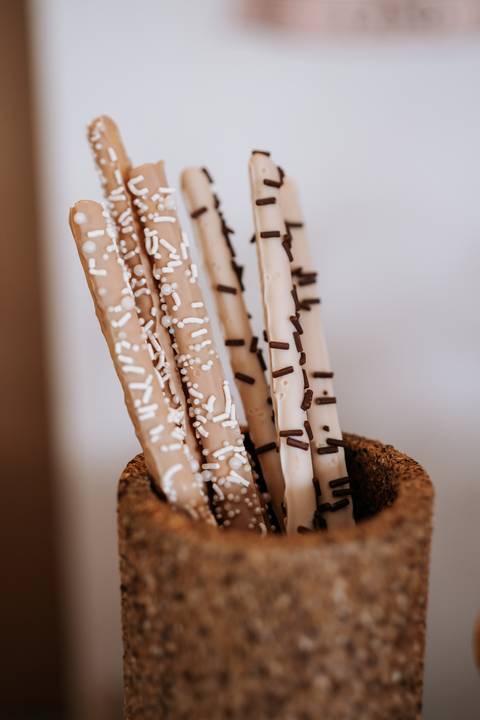 Foto em detalhe de palitos de chocolate decorados.'