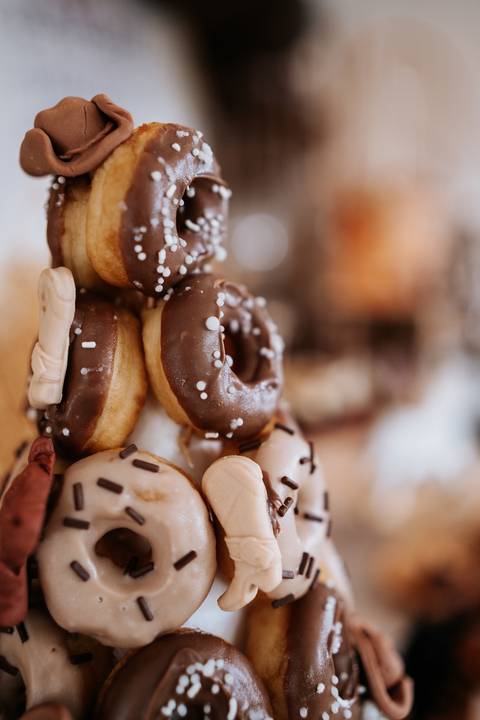 Foto aproximada de uma torre de donuts de chocolate.'