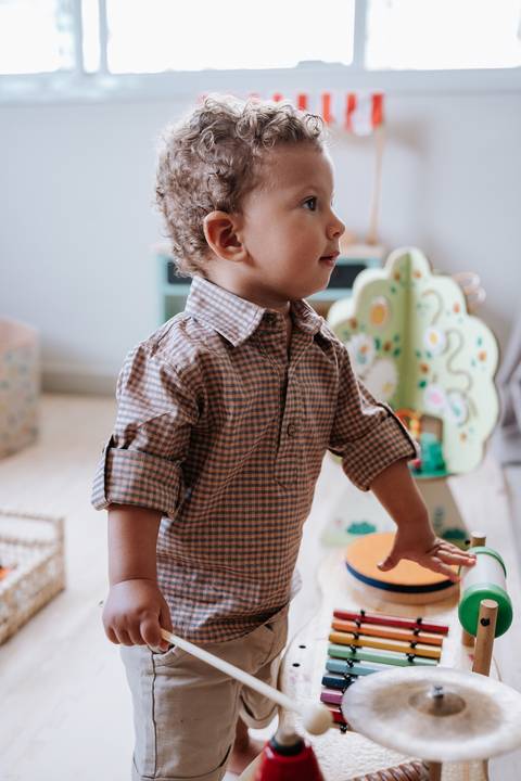 Foto do aniversariante de pé explorando os brinquedos temáticos.'