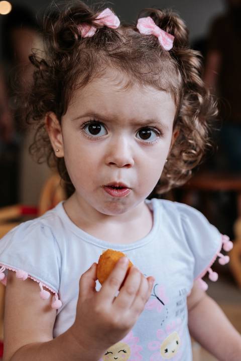 Foto de close de uma convidada mirim observando a festa.'
