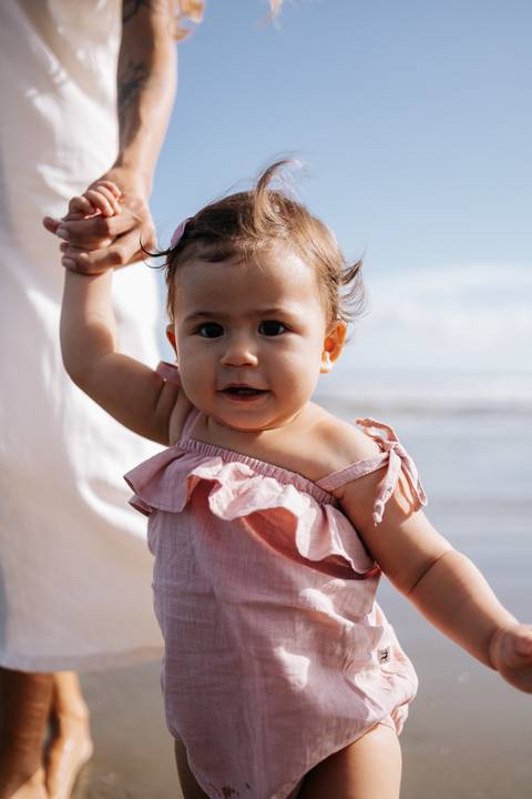 Foto de close do rosto da bebê enquanto é segurada pela mão.'