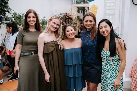 Foto da mãe posando com um grupo de amigas na festa.'