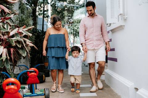 Foto da família caminhando junta em um corredor decorado da festa.'